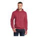 A man wearing a heather red Port & Company Core Fleece pullover hoodie.