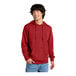 A man wearing a red District sweatshirt with a hood.