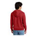 A man wearing a red District sweatshirt with a hood.
