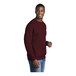 A man wearing a maroon Port & Company fleece sweatshirt.