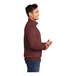 A man wearing a maroon Port & Company quarter-zip pullover.