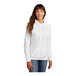 A woman wearing a white Port & Company fleece pullover hoodie.