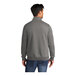 A man wearing a Port & Company graphite heather quarter-zip pullover sweatshirt.