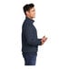 A man wearing a navy Port & Company fleece quarter-zip sweatshirt.