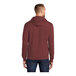A man wearing a maroon Port & Company pullover hoodie.