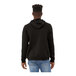 A man wearing a black Bella + Canvas pullover hoodie with a hood.