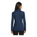 A woman wearing a Port Authority women's full-zip jacket in regatta blue and iron gray.