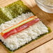 A sushi roll with Kokuho Rose medium grain white rice and fish on it.