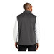 A man wearing a Port Authority graphite fleece vest.