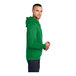 A person wearing a green Port & Company fleece pullover hoodie.