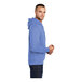 A man wearing a Carolina blue Port & Company pullover hoodie.