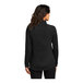 A woman wearing a black Port Authority quarter-zip sweatshirt.
