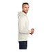 A man in an Oatmeal Heather Port & Company Core Fleece pullover hoodie standing.