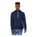 A man wearing a navy Bella + Canvas pullover hoodie.