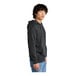 A man wearing a charcoal District sweatshirt with a hood.