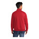 A man wearing a red Port & Company quarter-zip pullover sweatshirt.