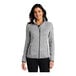 A woman wearing a gray Port Authority fleece sweater jacket.