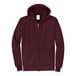 A maroon Port & Company zip up hoodie.