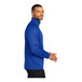 A man wearing a Port Authority blue and black quarter-zip sweatshirt.