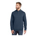 A man wearing a TravisMathew blue fleece 1/4 zip pullover.