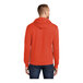 A man wearing an orange Port & Company Core Fleece pullover hoodie.