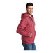 A person wearing a heather red Port & Company full-zip hoodie.