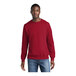 A man wearing a red Port & Company core fleece crewneck sweatshirt.