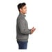 A man wearing a graphite heather Port & Company core fleece quarter-zip pullover.