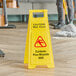 A yellow Lavex "CAUTION Wet Floor" sign on a wood floor.