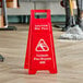 A Lavex red "CAUTION Wet Floor" sign on a wood floor.