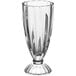 An Acopa clear soda glass with a foot.