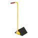 A black and yellow Vestil laminated rubber wheel chock with an ergonomic steel handle.