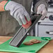 A person using Emperor's Select small plastic mandoline to cut potatoes.