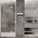 A close up of an Ariston tankless water heater installed in a white bathroom with a shower and sink.