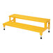 A yellow steel two-step step stool with black legs and a yellow rectangular object with holes.