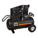 A black air compressor with wheels.