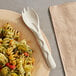 A plate of pasta with a World Centric compostable fiber spork on a table.