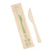 A World Centric compostable bamboo knife in green packaging.