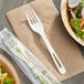 A World Centric compostable TPLA fork on a napkin next to a salad.