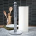 An Ironwood Gourmet white marble paper towel holder on a kitchen counter with a roll of paper towels on it.