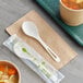 A white World Centric compostable spoon in a bowl of soup.