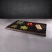 A rectangular faux zebra wood melamine riser with various vegetables on it.