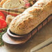 An Acacia Wood tray with a loaf of bread sliced on it.