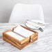 An Ironwood acacia wood napkin holder with a fork and knife inside.