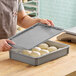 A person putting dough in a MFG Tray mini dough proofing box lid.