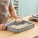 A man holding dough in a MFG Tray fiberglass dough proofing box.
