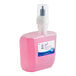 A Scott pink plastic container of foaming hand soap with a pump.