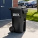 A large black rectangular wheeled trash can with a lid labeled 'Lavex Pro'.