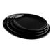 A stack of Tablecraft Sierra Collection black melamine serving platters.
