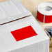 A white box with a roll of red rectangular Lavex inventory labels inside.